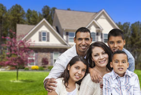 Happy Hispanic Family Portrait in Front of Beautiful House.